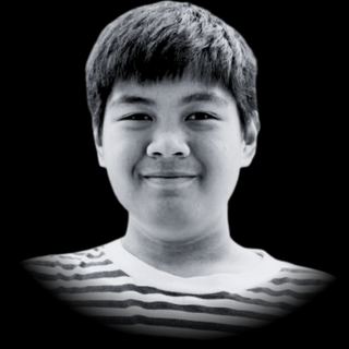 Potret monokrom remaja laki-laki dengan nama Biyo tersenyum ke arah kamera.